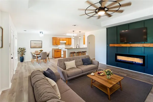 a living room with furniture flat screen tv and wooden floor