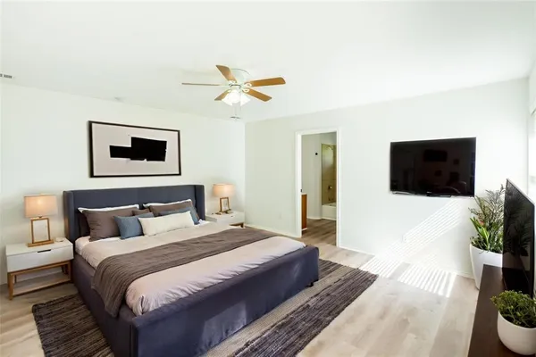 a bedroom with a bed and a potted plant