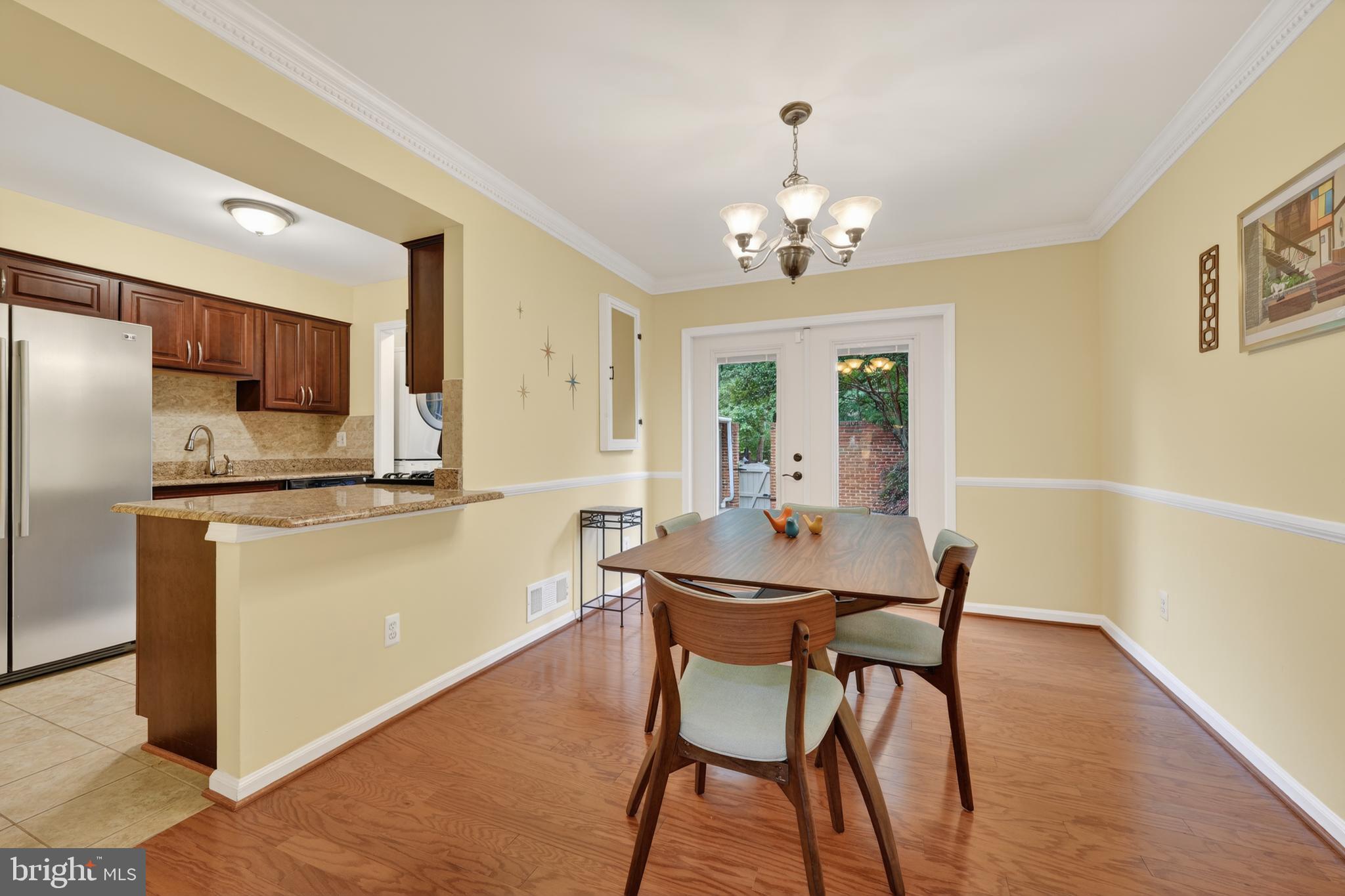8139 Carrleigh Parkway Springfield, VA 22152 - Photo 5 of 27 a view of a dining room with furniture a chandelier and wooden floor