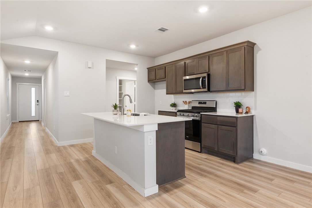 918 Kickapoo Lane College Station, TX 77845 - Photo 12 of 31 a kitchen with granite countertop a stove top oven and sink