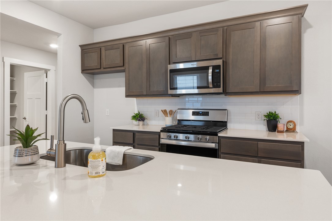 918 Kickapoo Lane College Station, TX 77845 - Photo 13 of 31 a kitchen with stainless steel appliances a sink a stove and cabinets