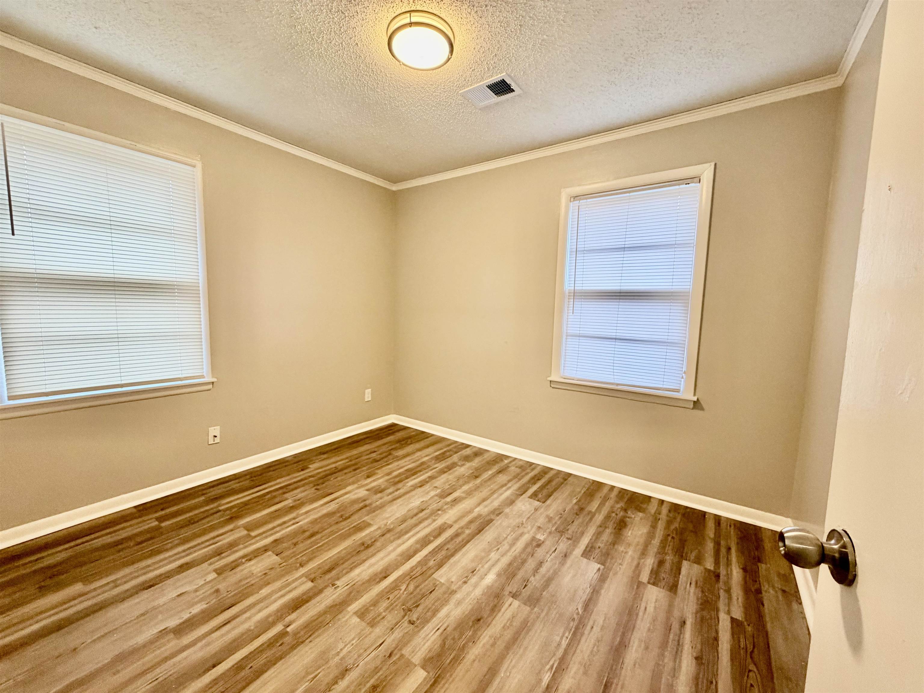 3345 Charlotte Road Memphis, TN 38109 - Photo 2 of 10 Bedroom with light wood-style floors, a textured ceiling, and crown molding