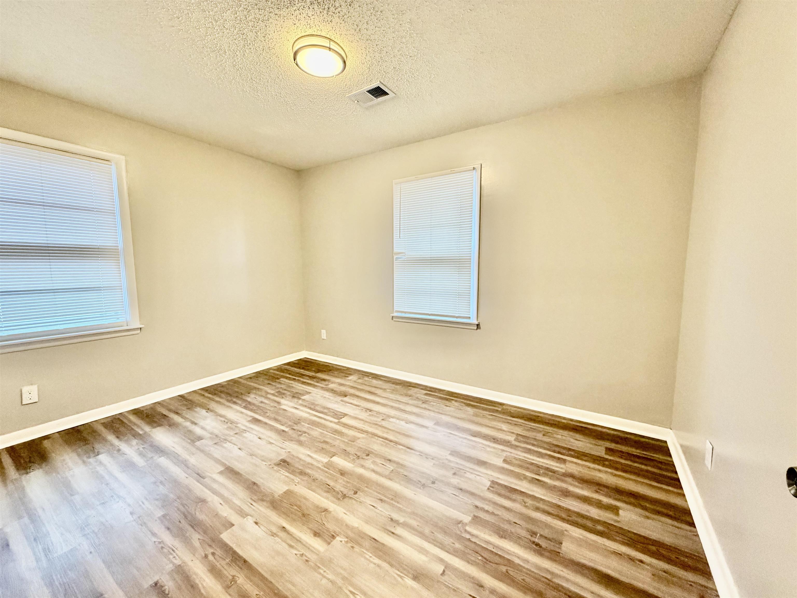 3345 Charlotte Road Memphis, TN 38109 - Photo 3 of 10 Bedroom with a textured ceiling and light wood-style floors