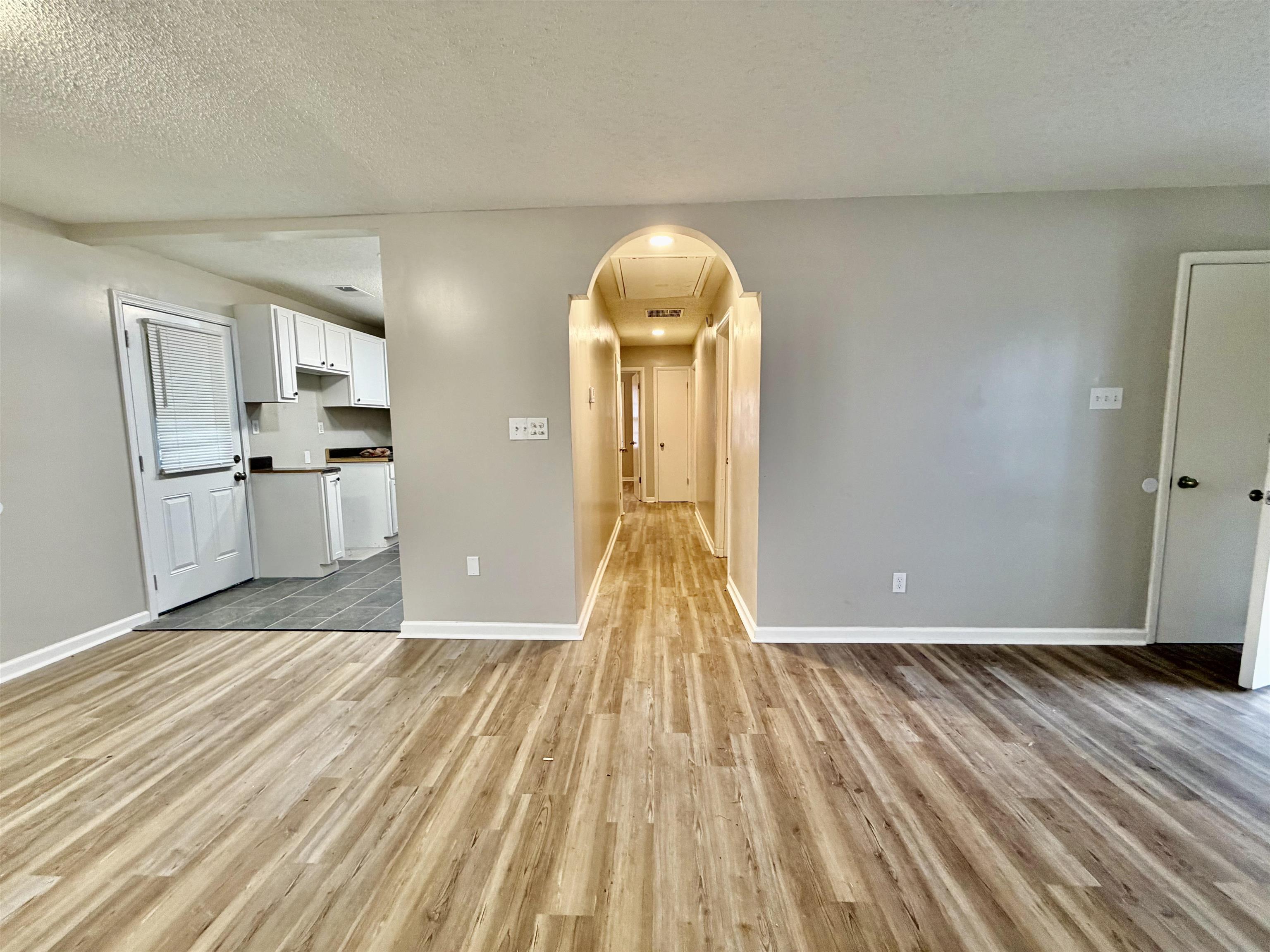 3345 Charlotte Road Memphis, TN 38109 - Photo 9 of 10 Living room featuring a textured ceiling and light wood-style flooring