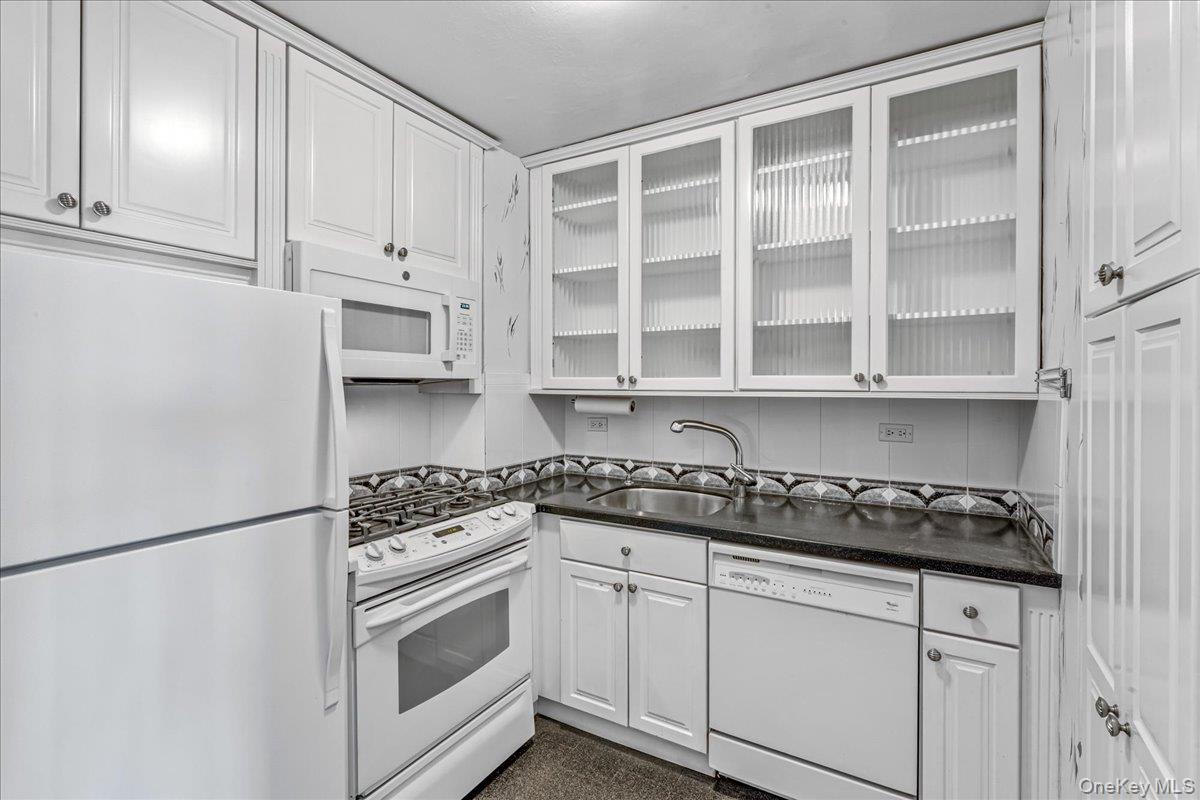 17-85 215th Street, Unit 6A Queens, NY 11360 - Photo 11 of 36 a kitchen with white cabinets and appliances