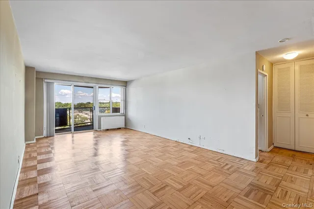 a view of an empty room with window and cabinet