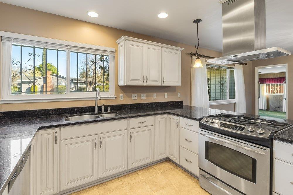 10486 Spaulding Way Rancho Cordova, CA 95670 - Photo 14 of 74 a kitchen with granite countertop a sink stainless steel appliances white cabinets and a window