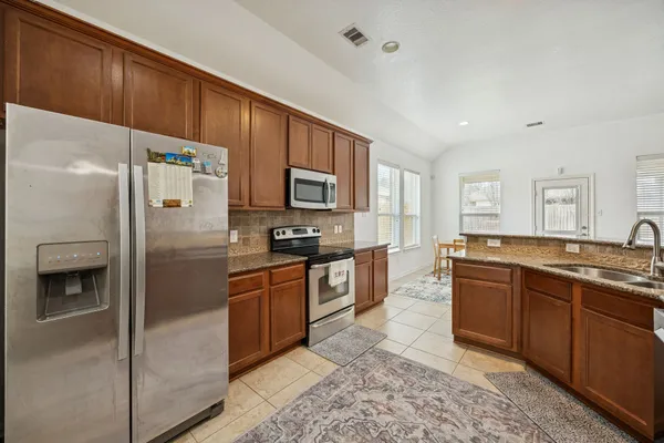 a large kitchen with cabinets stainless steel appliances and a center island