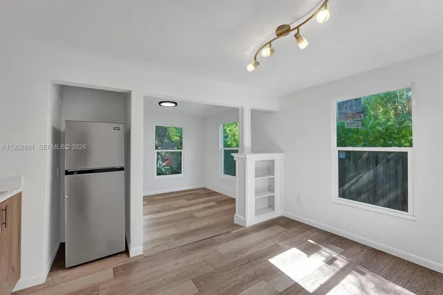 a view of empty room with wooden floor and window