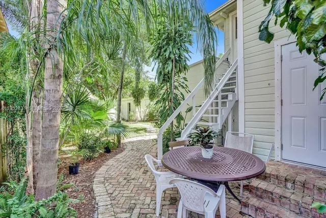 a view of a house with backyard and sitting area