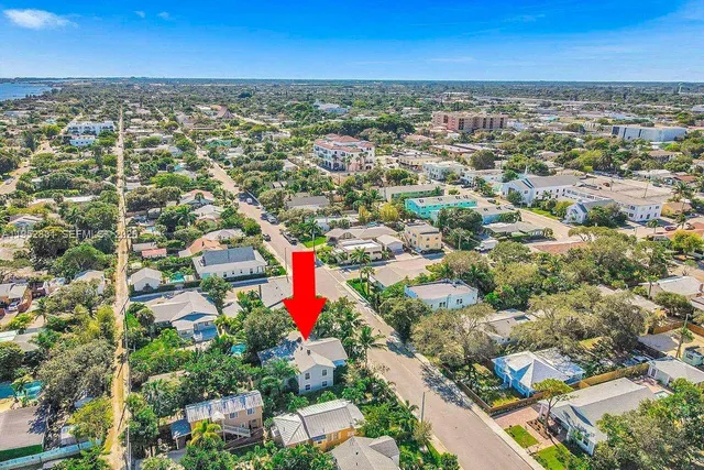 an aerial view of residential houses with outdoor space and trees