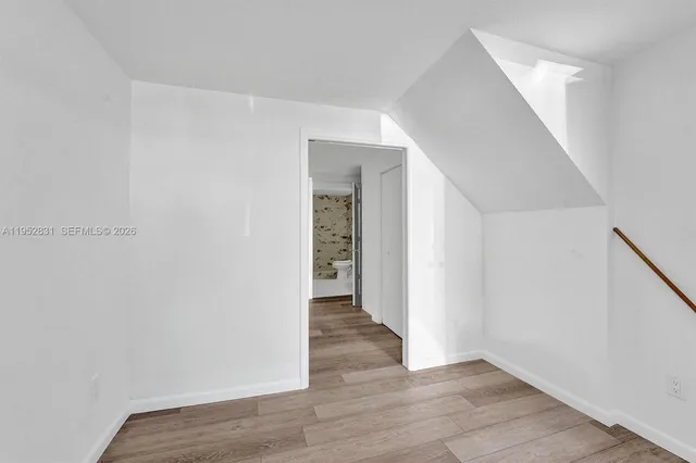 a view of an empty room with wooden floor