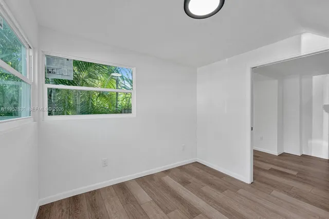 a view of a room with wooden floor and a window
