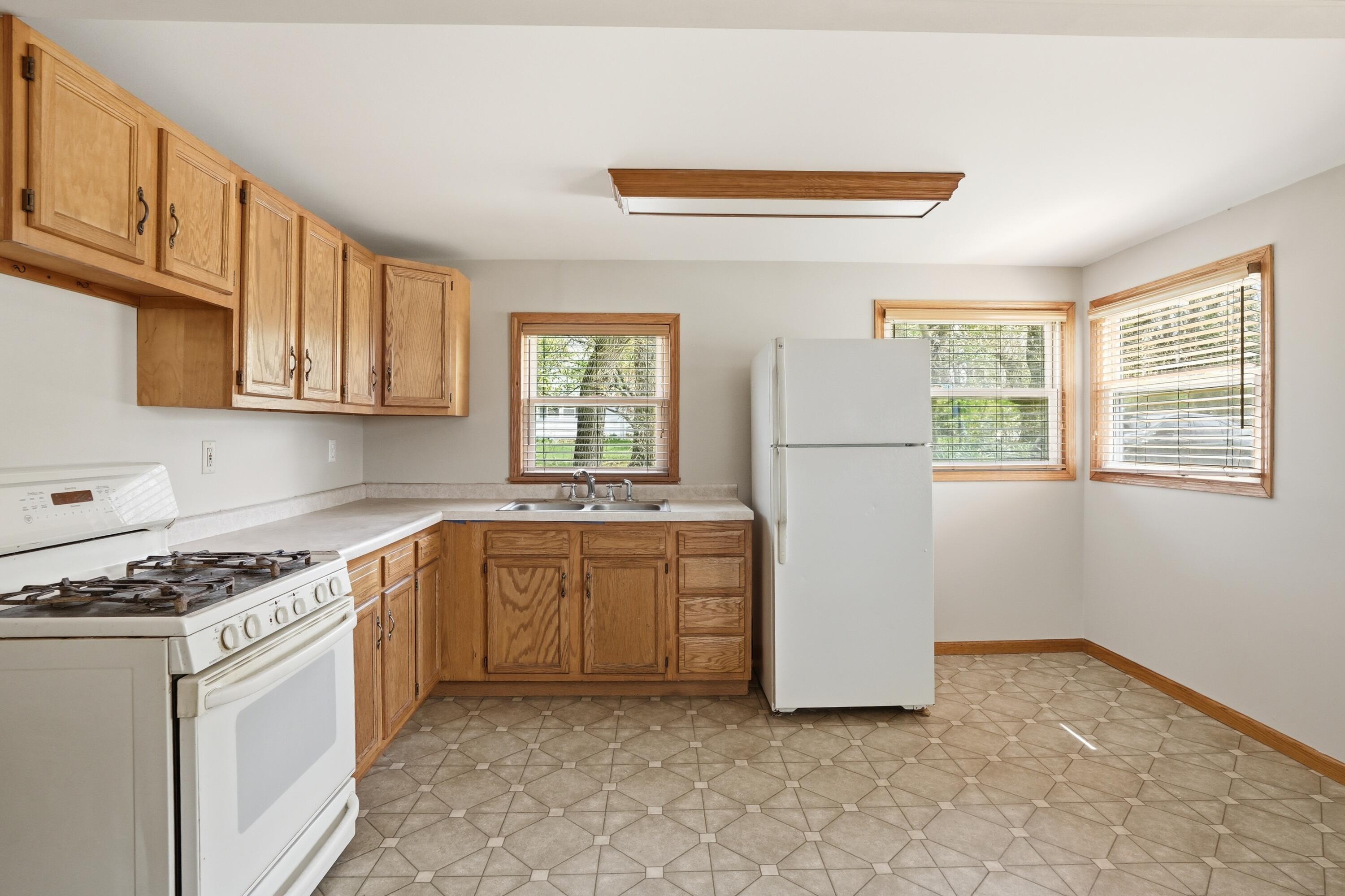 11131 Fathke Road Crown Point, IN 46307 - Photo 7 of 17 a kitchen with a refrigerator a stove a microwave and cabinets
