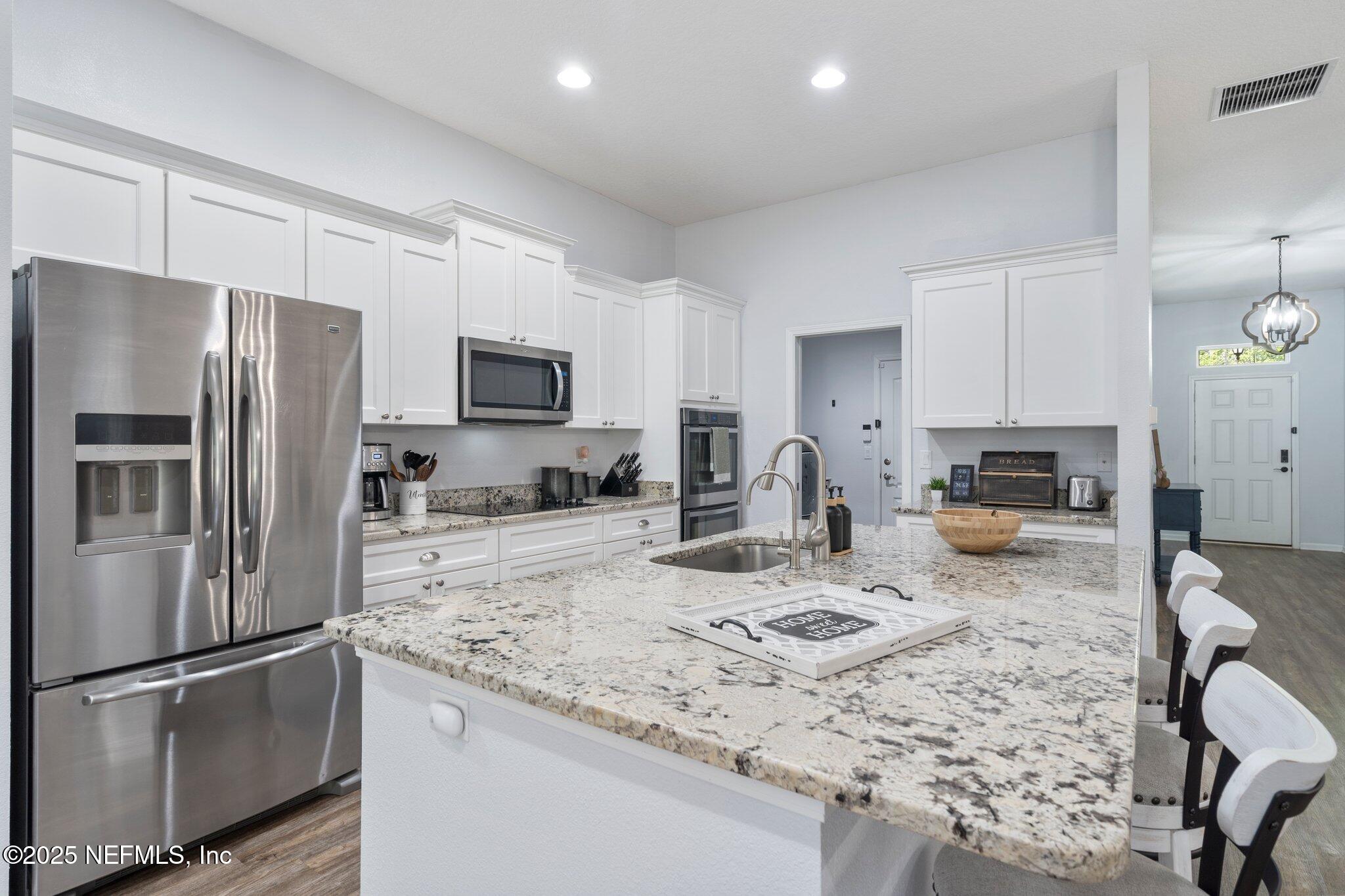 1309 Foxmeadow Trail Middleburg, FL 32068 - Photo 18 of 48 a kitchen with stainless steel appliances granite countertop a refrigerator stove microwave and sink