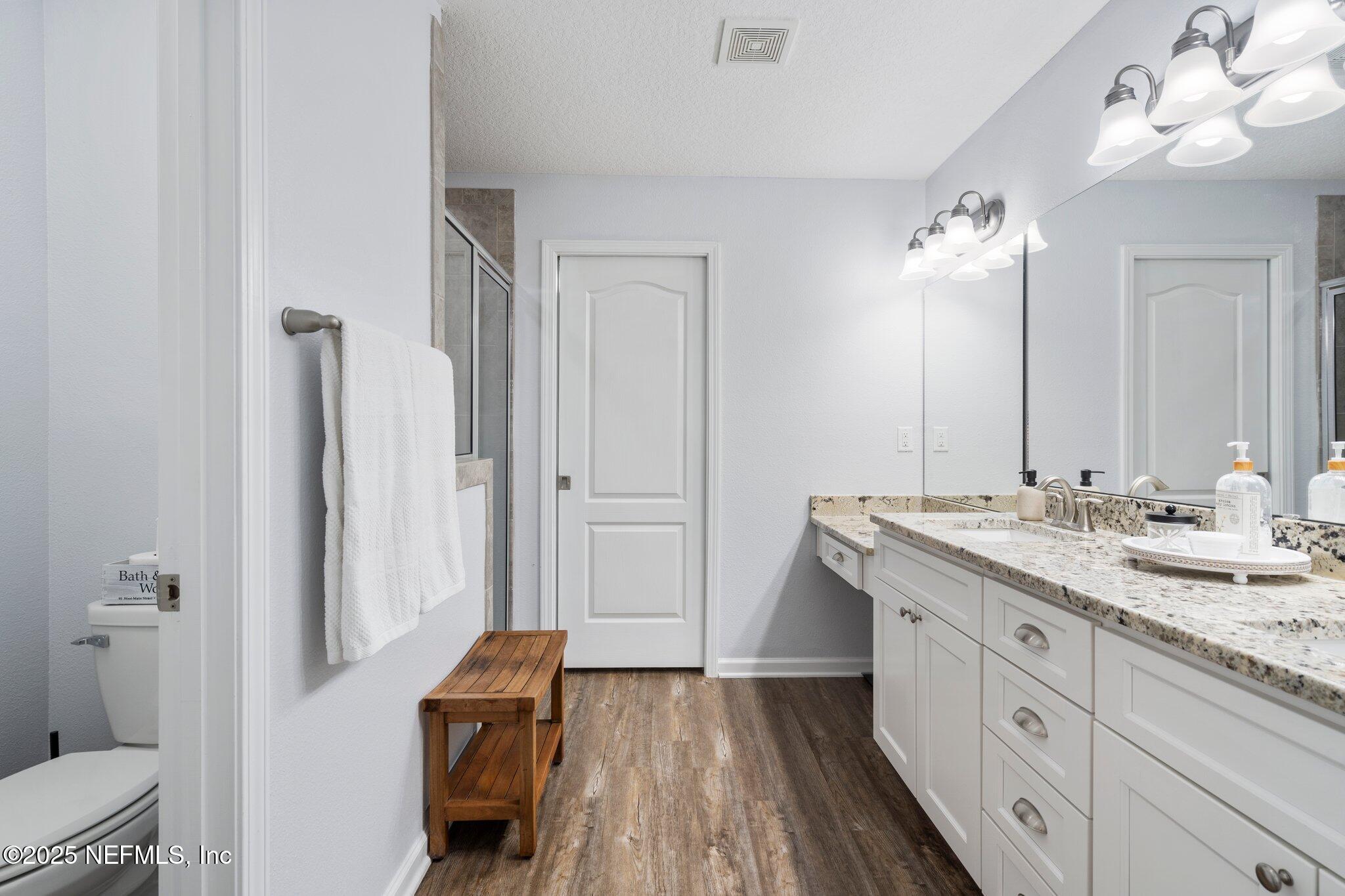 1309 Foxmeadow Trail Middleburg, FL 32068 - Photo 26 of 48 a spacious bathroom with a granite countertop sink a toilet and a mirror