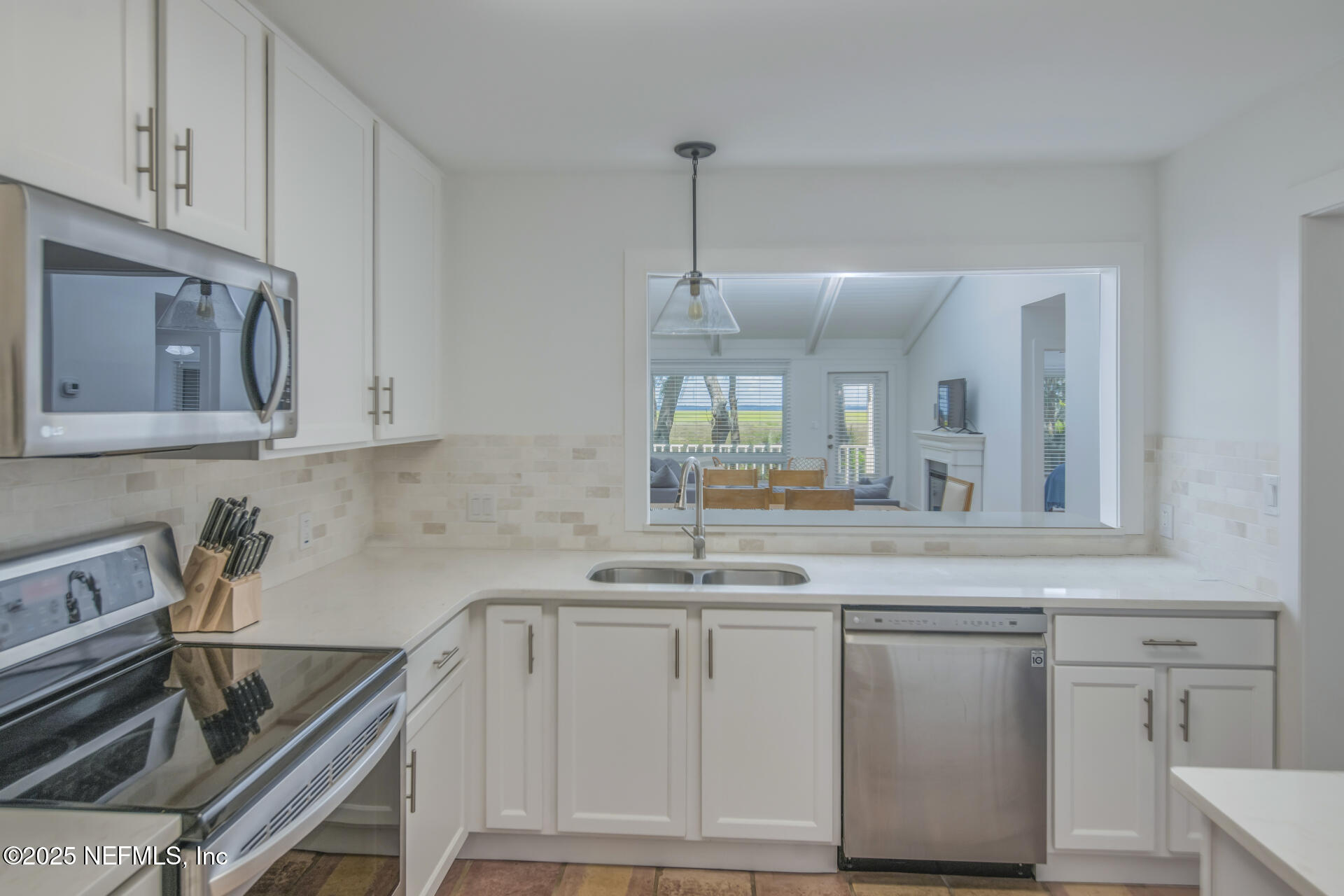 3426 Sea Marsh Road Fernandina Beach, FL 32034 - Photo 32 of 39 a kitchen with white cabinets and a stove