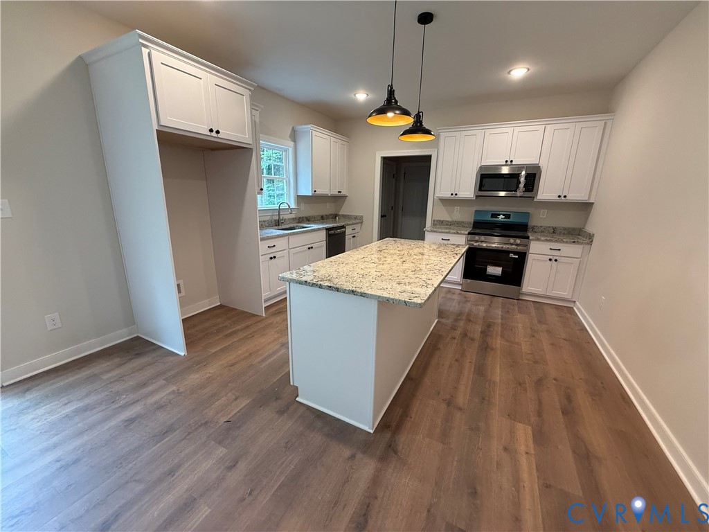 20545 Braxton Road Barhamsville, VA 23011 - Photo 8 of 22 a kitchen with stainless steel appliances granite countertop a sink a stove a refrigerator and a wooden floor