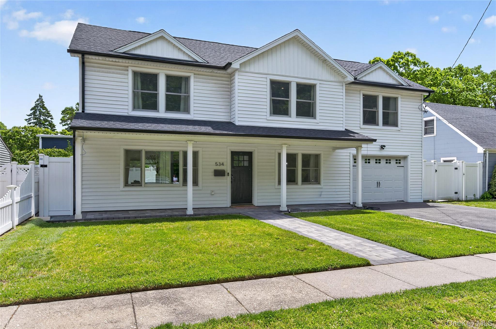 534 Riverside Avenue Massapequa, NY 11758 - Photo 3 of 28 a front view of a house with a yard and garage