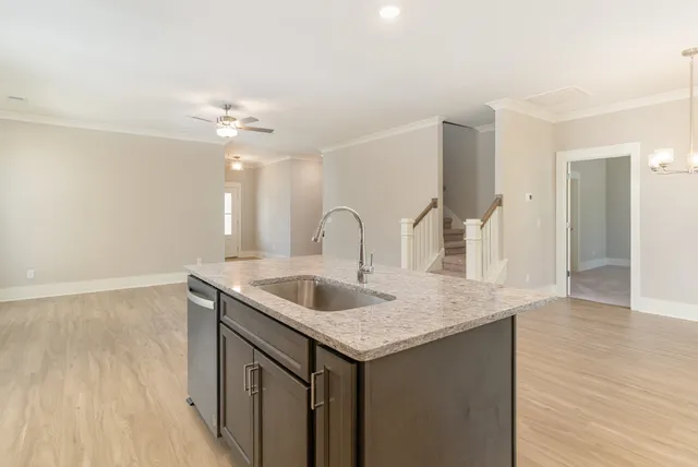 a kitchen with a sink and a wooden floor