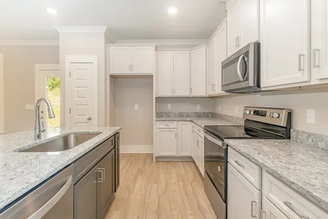 a kitchen with stainless steel appliances granite countertop a sink stove and cabinets