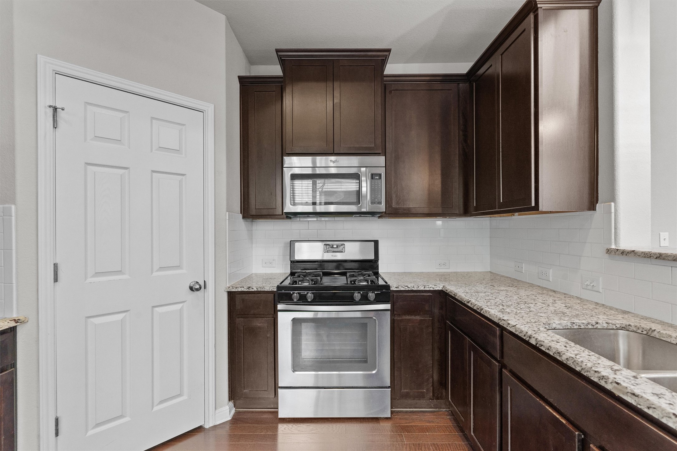 7709 Menchaca Road, Unit 22 Austin, TX 78745 - Photo 9 of 35 a kitchen with granite countertop white cabinets and stainless steel appliances