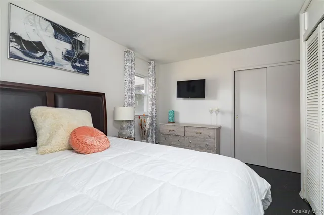 a bedroom with a bed and a flat screen tv