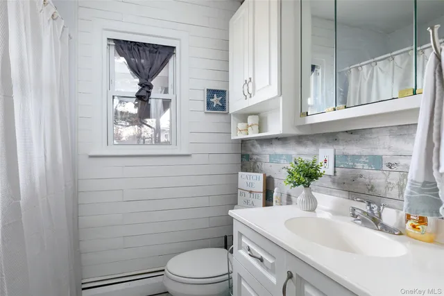a bathroom with a granite countertop toilet sink and mirror