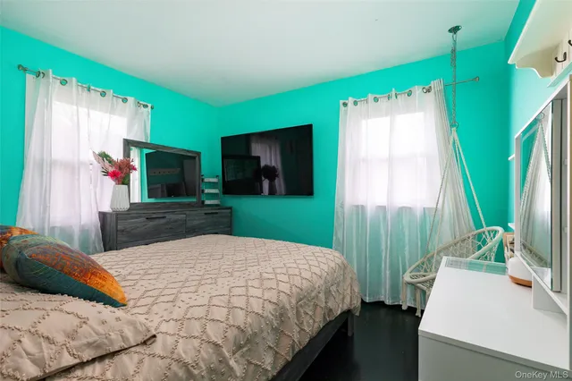 a bedroom with a bed and a flat tv screen