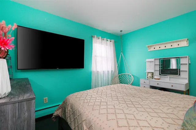 a bedroom with a bed and a flat screen tv