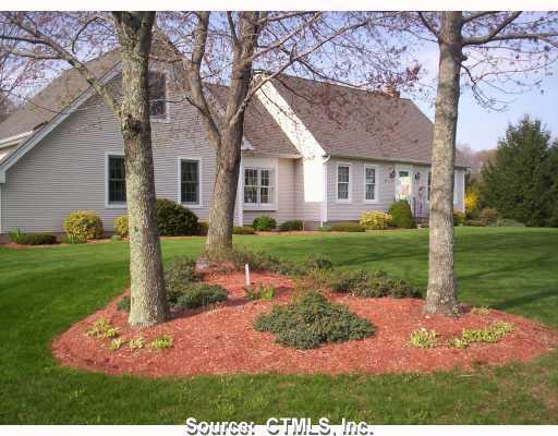 Exterior Front. This home is set off the road with well manicured landscaping, blooming trees and lush green lawn.
