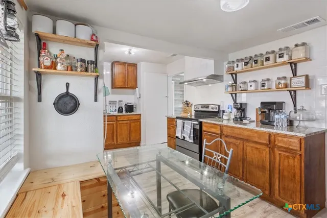 a kitchen with stainless steel appliances granite countertop a stove and a sink with cabinets