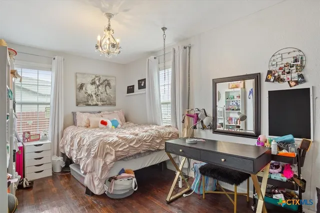 a bedroom with bed and a large mirror on the dresser