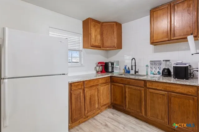 a kitchen with stainless steel appliances granite countertop a refrigerator sink and cabinets