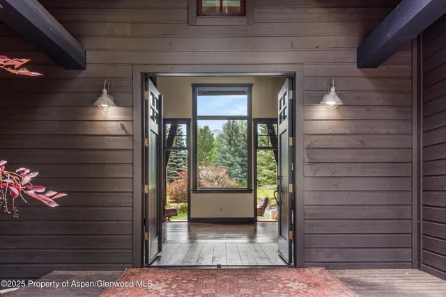 a kitchen with stainless steel appliances granite countertop a stove a refrigerator a oven a sink a dining table and chairs with wooden floor