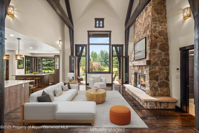 a dining hall with stainless steel appliances kitchen island granite countertop a table chairs and a view of living room