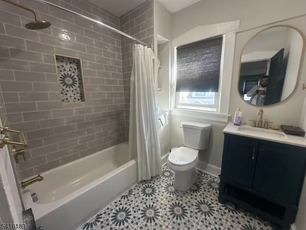 a bathroom with a granite countertop toilet a sink and bathtub