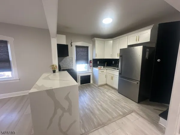 a kitchen with a refrigerator and a stove top oven