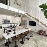 a kitchen with stainless steel appliances kitchen island granite countertop a refrigerator a stove a sink dishwasher and white cabinets with wooden floor