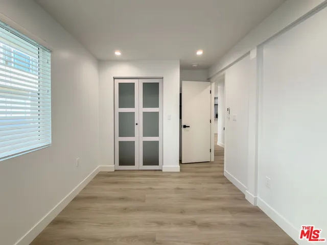 a view of empty room with wooden floor