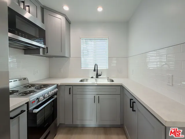 a kitchen with stainless steel appliances a sink stove and cabinets