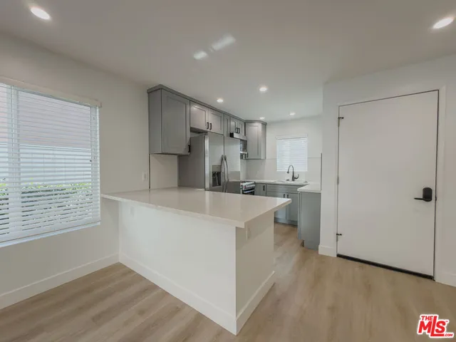 a kitchen with white cabinets and white appliances
