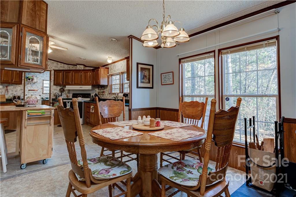 184 Terrys Gap Loop Road Fletcher, NC 28732 - Photo 7 of 28 a view of a dining room with furniture a chandelier and wooden floor