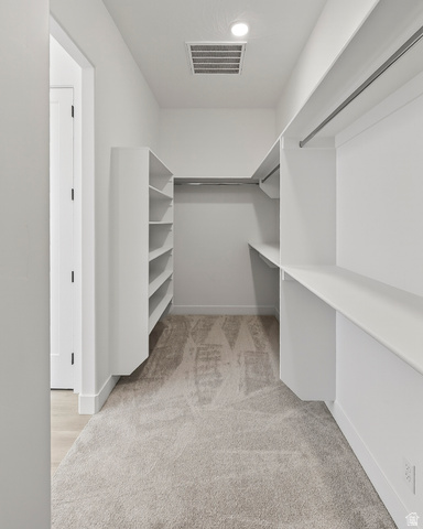 2862 South Mountain Rnch Road Cedar City, UT 84720 - Photo 29 of 64 Walk-in closet featuring built-in shelving, hanging rods, recessed lighting, and light-toned carpet flooring