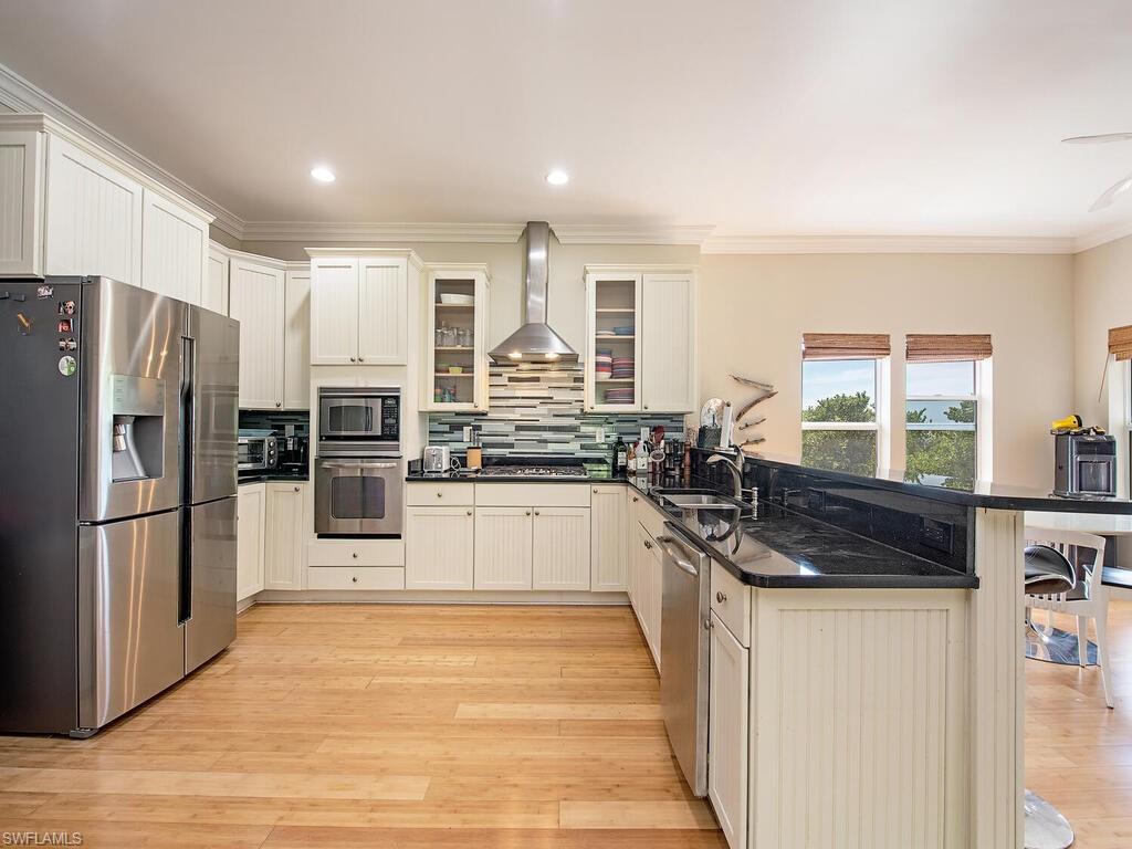 11231 Keewaydin Island Naples, FL 34113 - Photo 4 of 27 a kitchen with stainless steel appliances granite countertop a refrigerator and a stove top oven