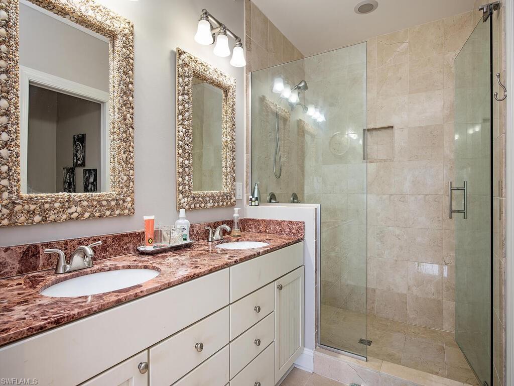 11231 Keewaydin Island Naples, FL 34113 - Photo 10 of 27 a bathroom with a granite countertop sink mirror and shower