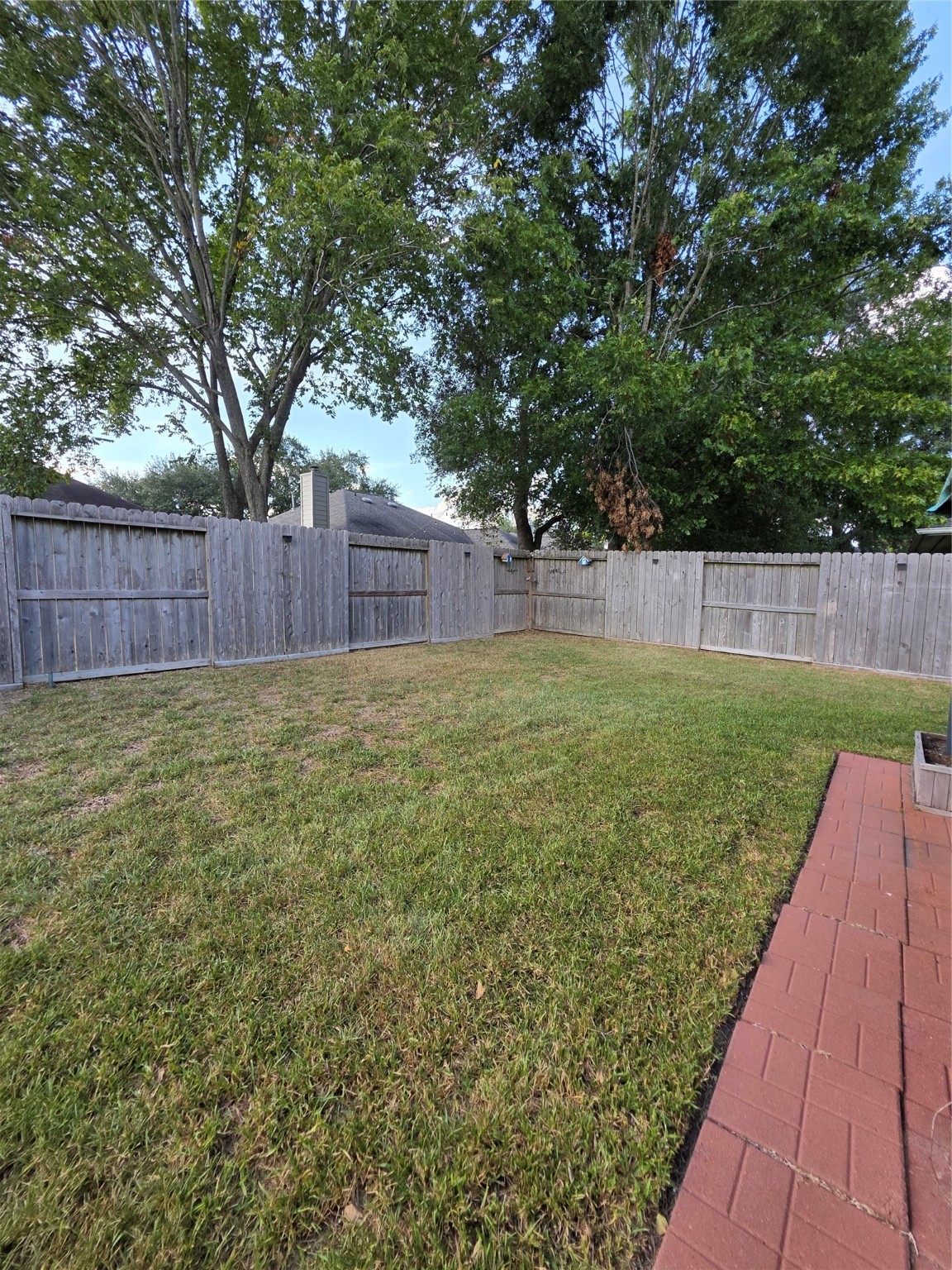 14925 Cypress Ridge Grove Lane Cypress, TX 77429 - Photo 22 of 30 a view of a backyard with a large tree and wooden fence