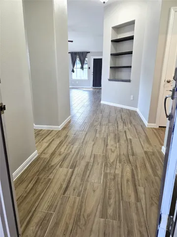 a view of empty room with wooden floor
