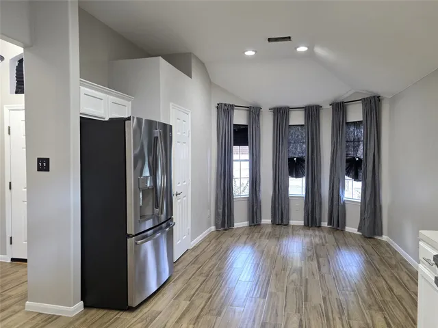 a view of a refrigerator in kitchen and wooden floor