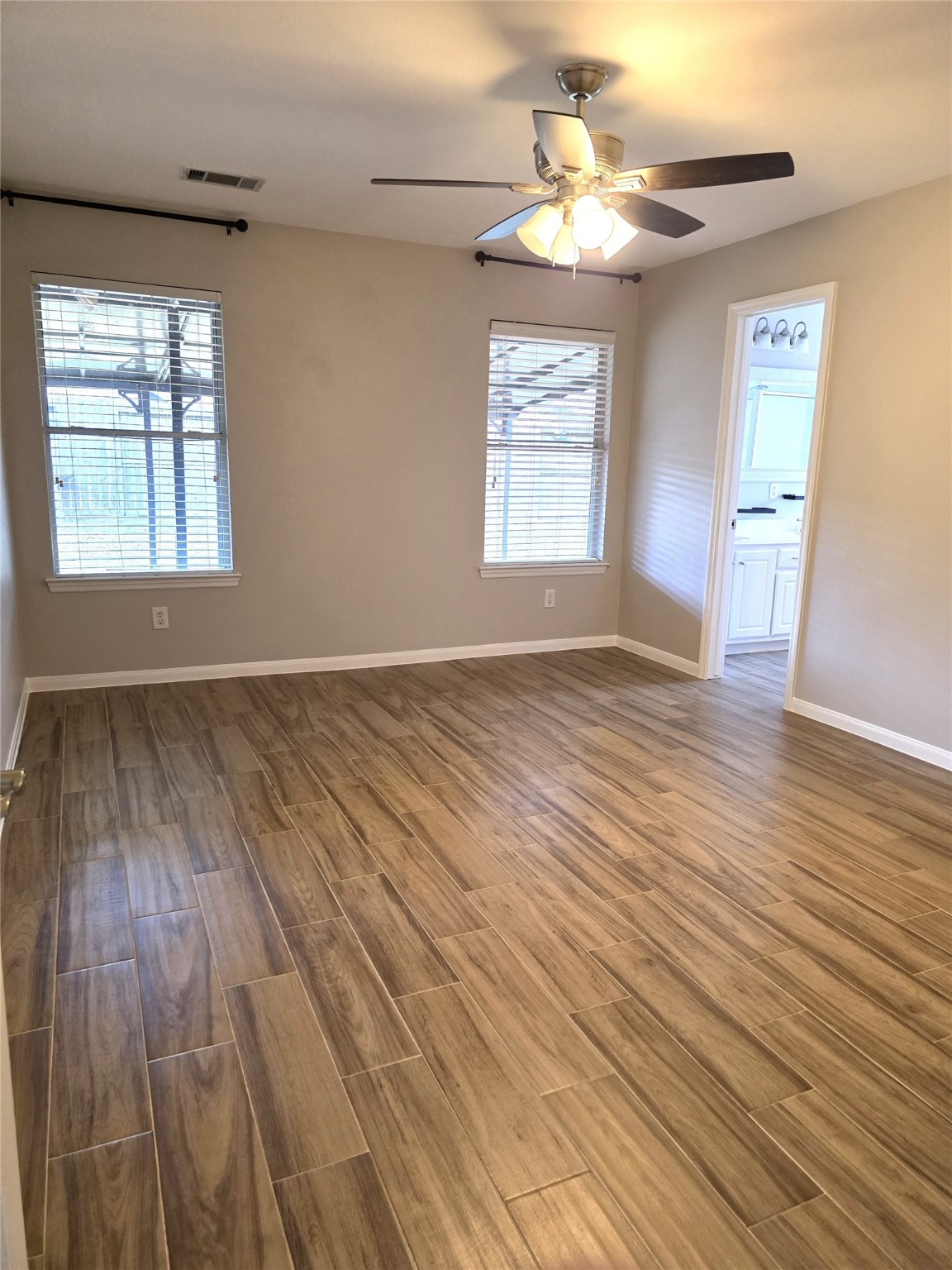14925 Cypress Ridge Grove Lane Cypress, TX 77429 - Photo 9 of 30 an empty room with wooden floor chandelier fan and windows